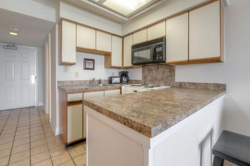 a kitchen with white cabinets and granite counter tops at Kingfisher Inn in Myrtle Beach