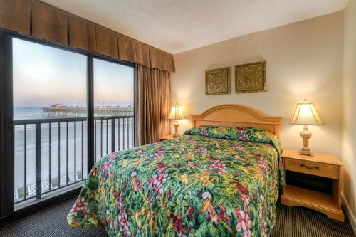 a bedroom with a bed and a view of the ocean at Kingfisher Inn in Myrtle Beach