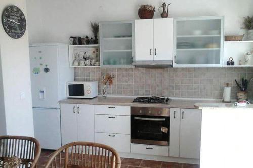 cocina con armarios blancos y fogones en Apartment Petrovic, en Pirovac