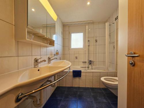 ein Badezimmer mit einem Waschbecken, einer Badewanne und einem WC in der Unterkunft Nicoletta in Saas-Fee