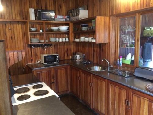 y cocina con armarios de madera y fogones. en Kameelkop Nature Reserve Lodge & Chalets, en Wasbank