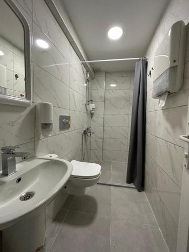 a white bathroom with a toilet and a sink at KOZA HOSTEL Coffee & Chill in Çekirge