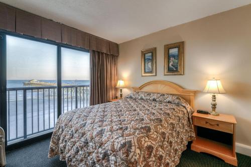 a bedroom with a bed and a view of the ocean at Kingfisher Inn in Myrtle Beach