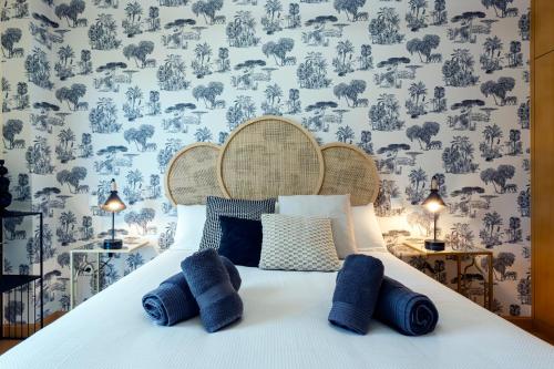 a bedroom with a bed with blue pillows at La Quinta Esencia by Unique Rooms in Burgos
