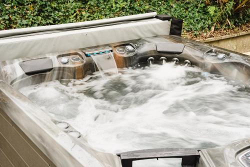 a jacuzzi tub filled with white water at Timber Hill - Parkfields in Haverfordwest