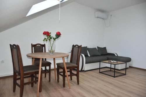 - un salon avec une table et un canapé dans l'établissement Bella apartmani, à Požarevac