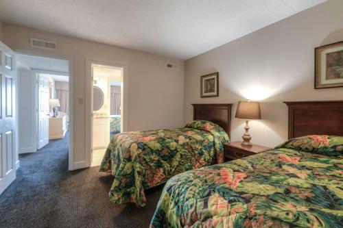 a hotel room with two beds and a hallway at Kingfisher Inn in Myrtle Beach
