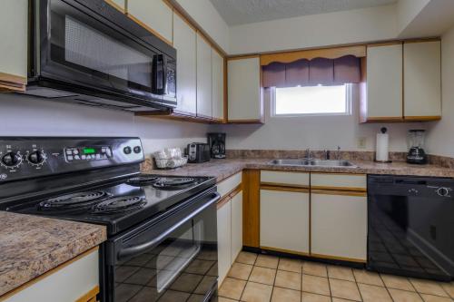 a kitchen with a stove and a sink at Kingfisher Inn in Myrtle Beach