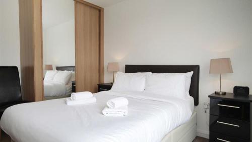 a bedroom with a large white bed with two towels on it at Marina Villas, Trawler Road, Marina in Swansea
