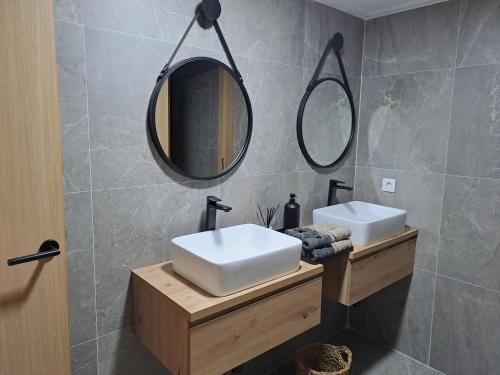 Baño con 2 lavabos y espejo en DON LEONE Hotel, en Alginet
