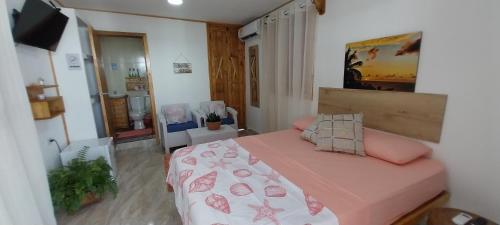 a bedroom with a bed with a pink bedspread at POSADA ALEENY in Providencia
