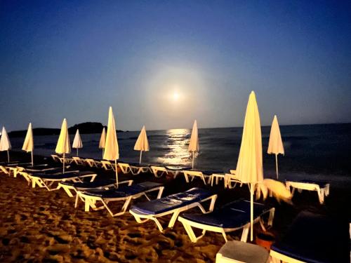 a group of chairs and umbrellas on a beach at The Best Apartment on the beach 'Caesar Beach' Bogaz, North Cyprus in Boğaz