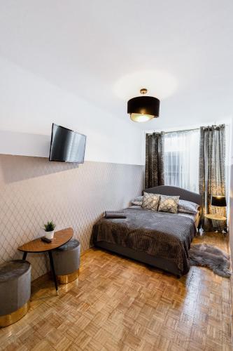 a bedroom with a bed and a table at ClickTheFlat Norblin Factory Apart Rooms in Warsaw