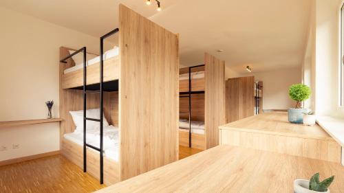 a bedroom with wooden bunk beds and a desk at Henrys Sleeping am Augsburger Eiskanal in Augsburg