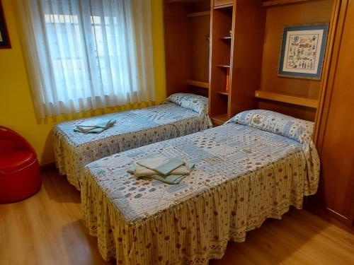 Zimmer mit 2 Betten und einem Fenster in der Unterkunft Villa Mercedes in Luarca