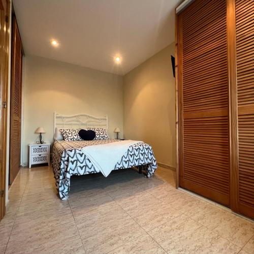 a bedroom with a bed with a black and white bedspread at Habitación Atalaya in Olivella