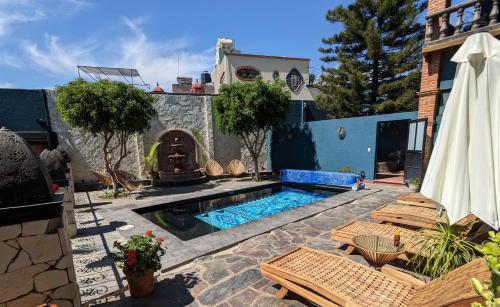 un patio trasero con piscina y una casa en La Joya Azul SMA - LGBTQS, en San Miguel de Allende