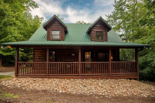 a large wooden cabin with a green roof at Elegant & Cozy Cabin Near Pigeon Forge in Sevierville