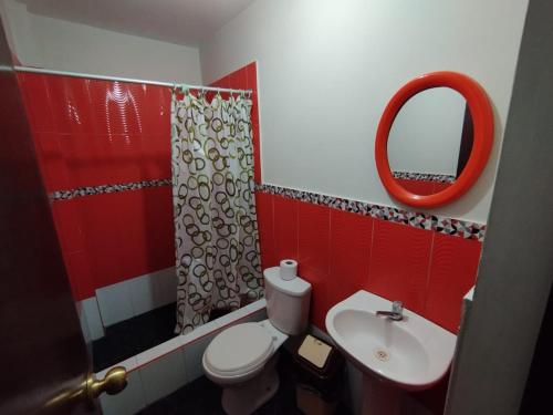 uma casa de banho com um WC, um lavatório e um espelho. em Soinca Backpacker Hospedaje em Paracas