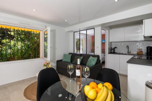 Il dispose d'une cuisine et d'un salon avec une table en verre et des fruits. dans l'établissement Le Cocon du Fort - Climatisation - Wifi - Parking - MyBestLoc, à Six-Fours-les-Plages