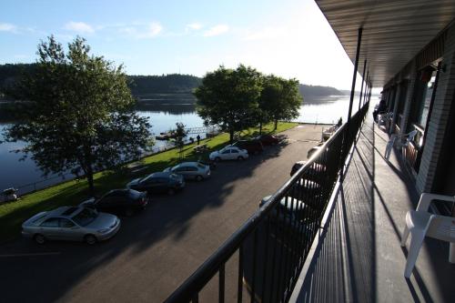 a balcony with cars parked in a parking lot next to a lake at Motel Panoramique in Saguenay