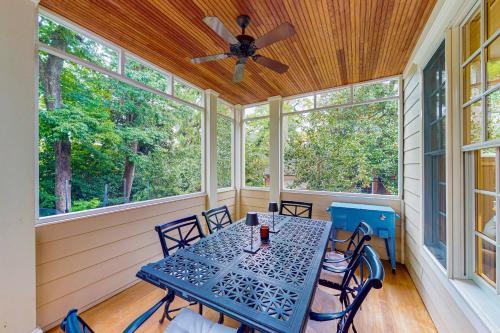 a screened porch with a table with chairs and a ceiling fan at Ensign's Ridge in Annapolis