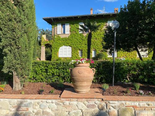 a large vase with flowers in front of a house at Agriturismo San Tommaso in Pomarance