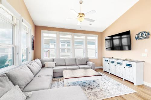 a living room with a couch and a flat screen tv at Vanodi Landing in North Topsail Beach