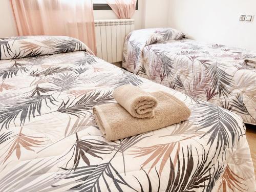 1 dormitorio con 2 camas con hojas de palmera en Ático con Vistas al Mar a un Paso del Centro en Blanes