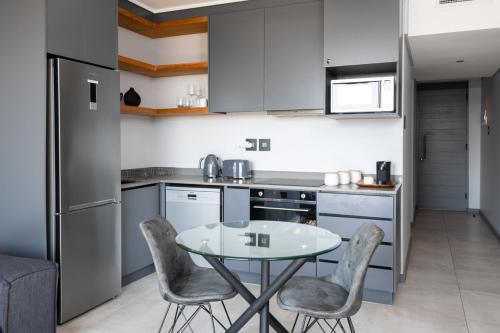 Una cocina con una mesa y sillas en una cocina. en Luxury Bellagio 303 with Sea Views and Inverter, en Durban