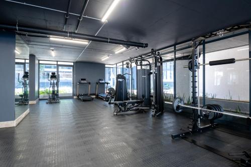 Un gimnasio con cintas de correr y máquinas en una habitación. en Luxury Bellagio 303 with Sea Views and Inverter, en Durban