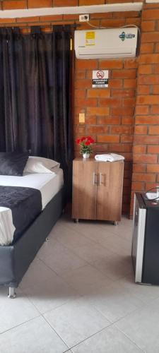 Un dormitorio con una cama y una mesa con flores. en Hotel Boutique Los Gentiles, en Santa Fe de Antioquia