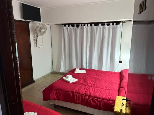 a red couch in a room with a window at Hotel Hanna in Mar del Plata