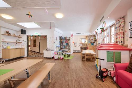 a room with a toy kitchen and a play area at Hotel Austria in Lech am Arlberg