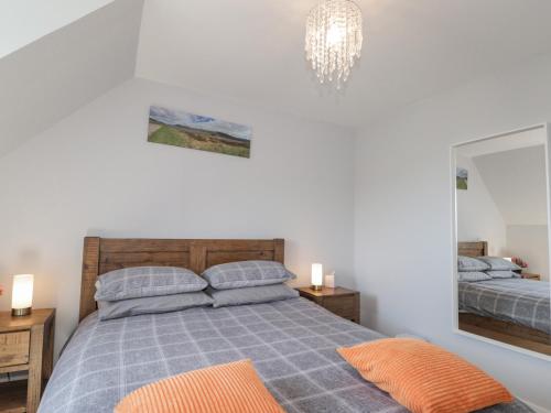 a bedroom with a bed and a mirror and a chandelier at Beachview in Oldshoremore