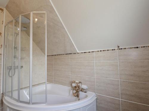 a bathroom with a shower and a tub at Beachview in Oldshoremore