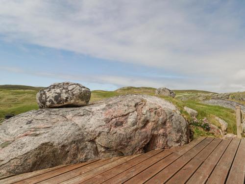 a large rock sitting on top of a wooden deck at Beachview in Oldshoremore