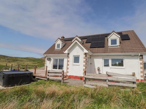 a house with solar panels on top of it at Beachview in Oldshoremore