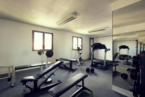 a gym with several tread machines and a mirror at Mercure Perpignan Centre in Perpignan