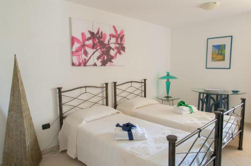 two beds in a room with white walls at B&B Le Fresie in Nuoro