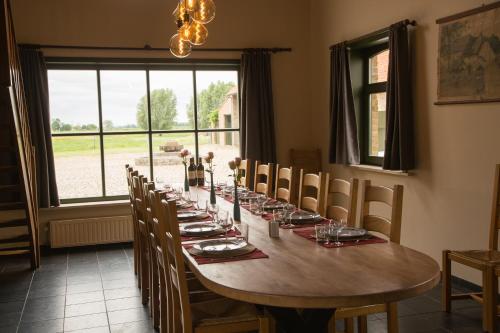 een eetkamer met een lange tafel en stoelen bij Holiday Home Slaghekhoeve in Nieuwkapelle