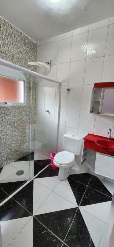 a bathroom with a toilet and a sink and a shower at Casa em Caraguatatuba com piscina e churrasqueira in Caraguatatuba