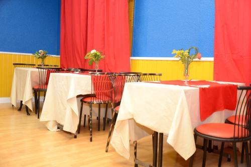 a group of tables with red and blue walls at Hôtel Aux Armes de Belgique in Lourdes