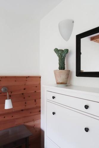 a white dresser with a mirror and a plant on it at Schöne Wohnung, zentral, mit Panorama-Aussicht in Grossarl