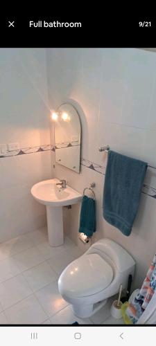 a bathroom with a white toilet and a sink at Juan Dolio Guababerry Resort in Juan Dolio