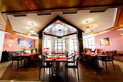 - un restaurant avec des tables et des chaises dans une salle dans l'établissement CityHotel Feuerbach, à Stuttgart