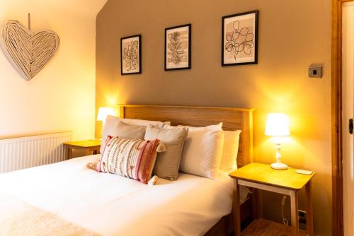 um quarto com uma cama com dois candeeiros e um coração na parede em Chapel Street Cottage em Coton in the Elms