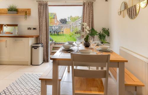uma cozinha e sala de jantar com mesa e cadeiras em Chapel Street Cottage em Coton in the Elms