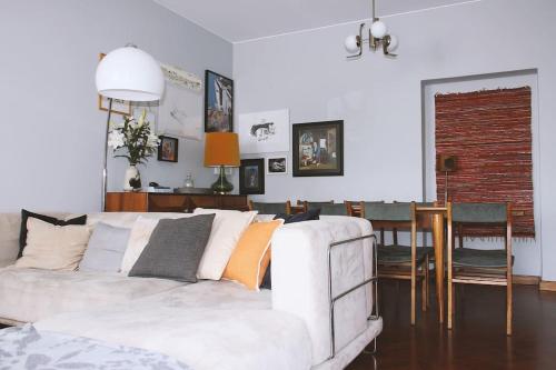 a living room with a white couch and a dining room at Dorme in Porto