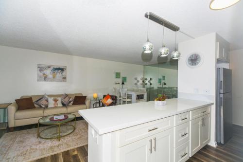 a kitchen with white cabinets and a living room at Discovery Bay 3513 in Honolulu